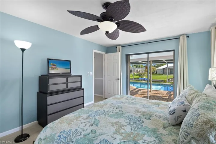 Carpeted bedroom with ceiling fan and access to exterior