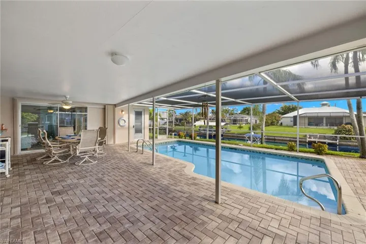 View of swimming pool featuring a lanai and a patio area