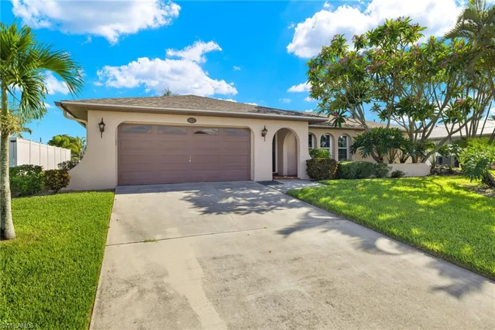 View of front of house featuring a garage and a front yard