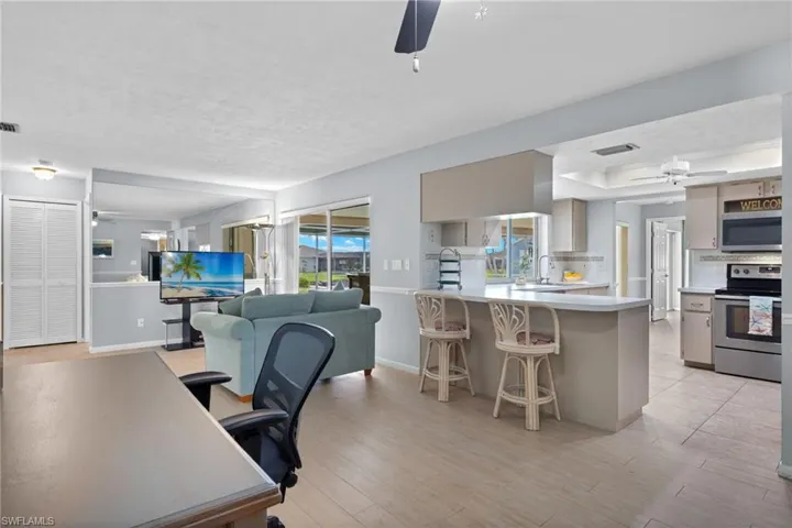 Office with sink, a wealth of natural light, ceiling fan, and light plank floors