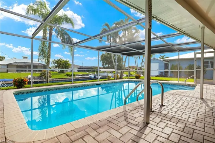 View of pool featuring a lawn, a lanai, and a patio area