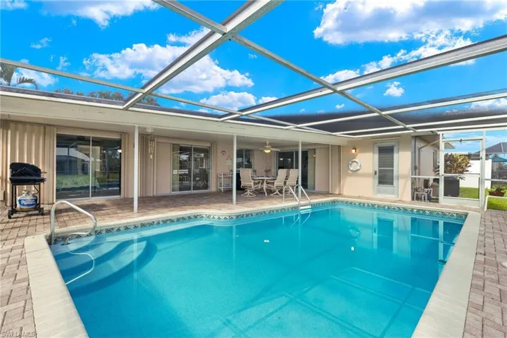 View of pool featuring a patio and screen enclosure