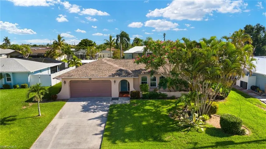 View of front of property with a garage and a front lawn
