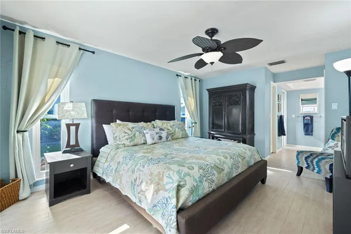 Bedroom featuring ceiling fan, and multiple windows
