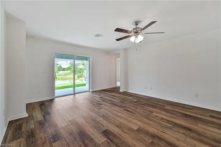 Empty room featuring ceiling fan and dark hardwood / wood-style floors