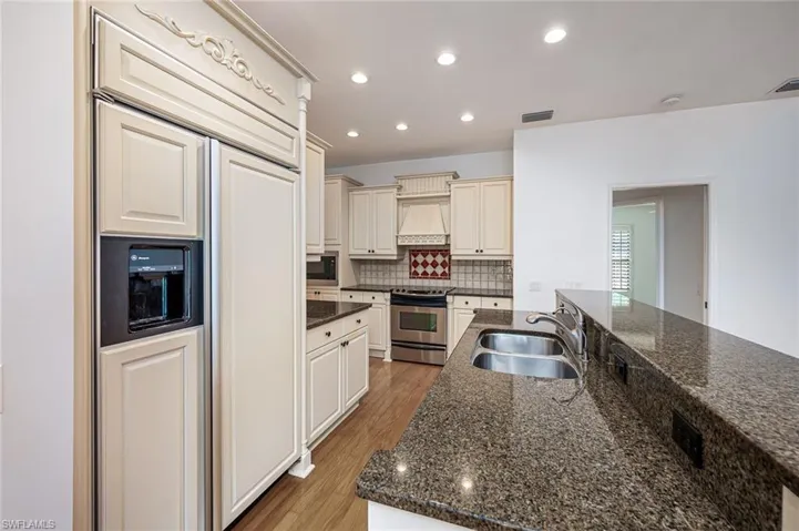 Kitchen featuring granite counter tops custom backsplash and lots of cabinets