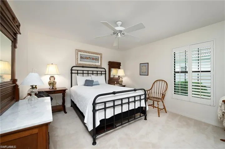 Bedroom featuring light colored carpet, baseboards, and ceiling fan
