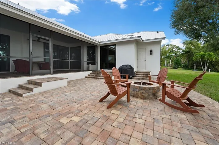 View of patio / terrace with a sunroom, area for grilling, and an outdoor fire pit