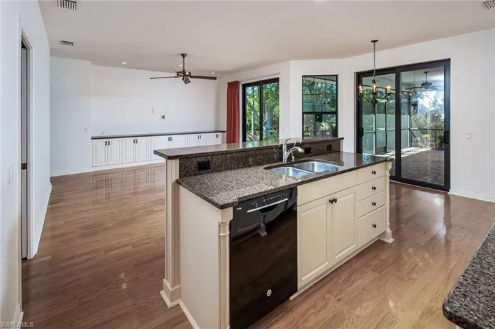 Kitchen island with sink overlooking family room, breakfast nook and lovely view of outside with water views.