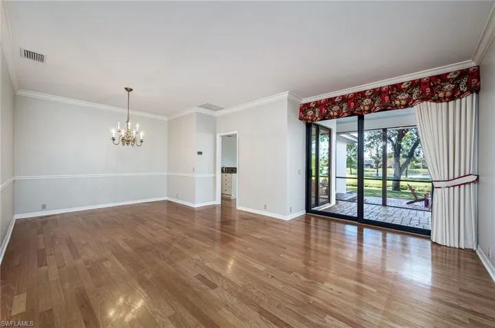 Living room with dining area and view of water feature, screened lanai and patio