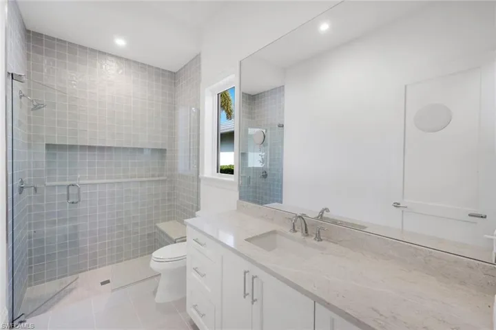 Full bath featuring vanity, light tile patterned floors, a shower stall, and recessed lighting