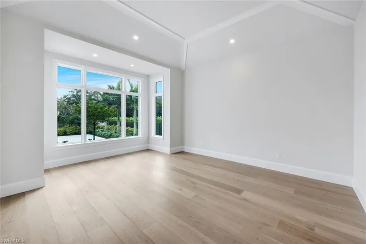 Unfurnished room with recessed lighting, light wood-style flooring, and lofted ceiling