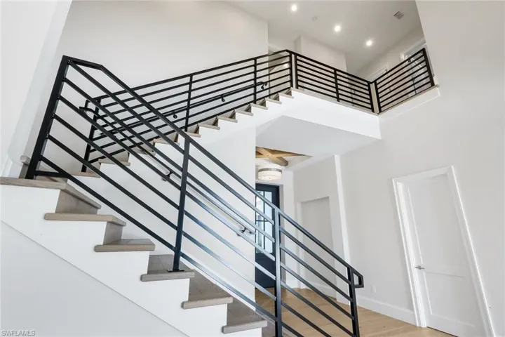 Staircase featuring wood finished floors and a high ceiling