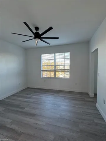Unfurnished room with dark hardwood / wood-style floors and ceiling fan