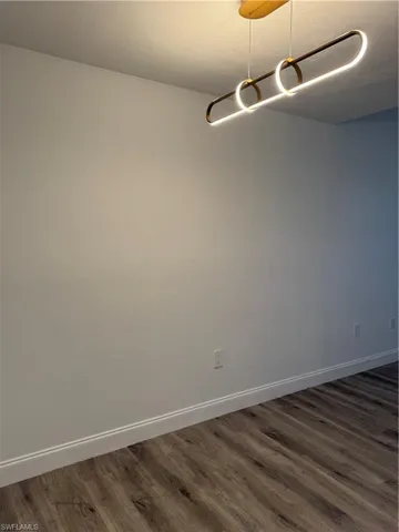 Unfurnished room featuring dark hardwood / wood-style floors