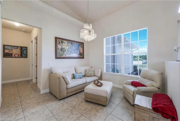 Tiled living room with lofted ceiling and a notable chandelier