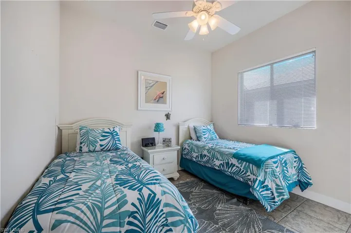Tiled bedroom featuring ceiling fan