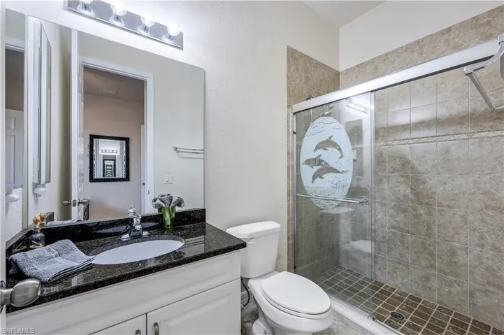 Bathroom with vanity, toilet, and an enclosed shower