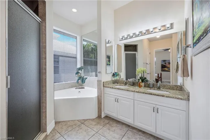 Bathroom with vanity, separate shower and tub, and tile patterned floors