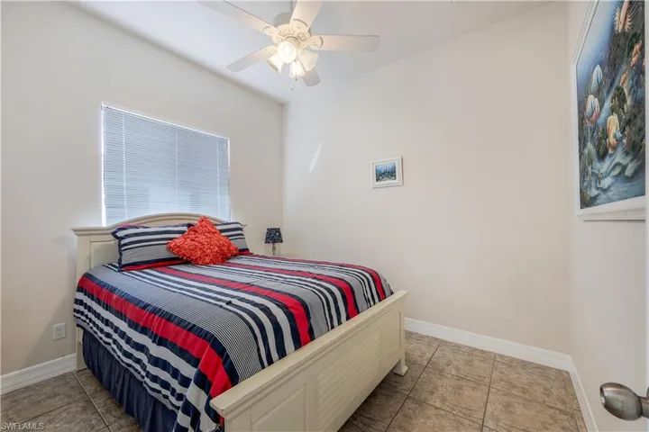 Bedroom featuring light tile patterned floors and ceiling fan