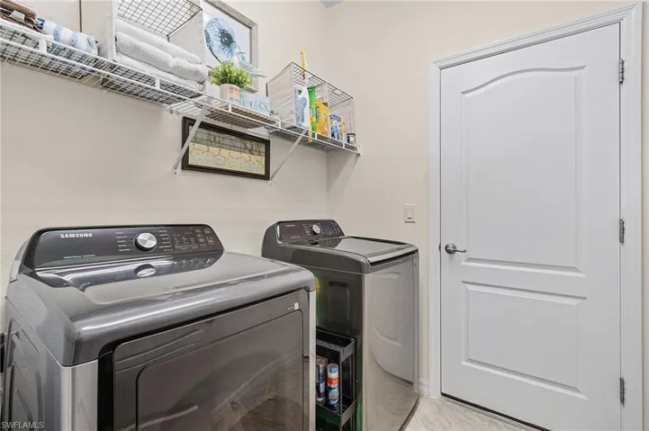 Laundry area with light tile patterned floors and separate washer and dryer