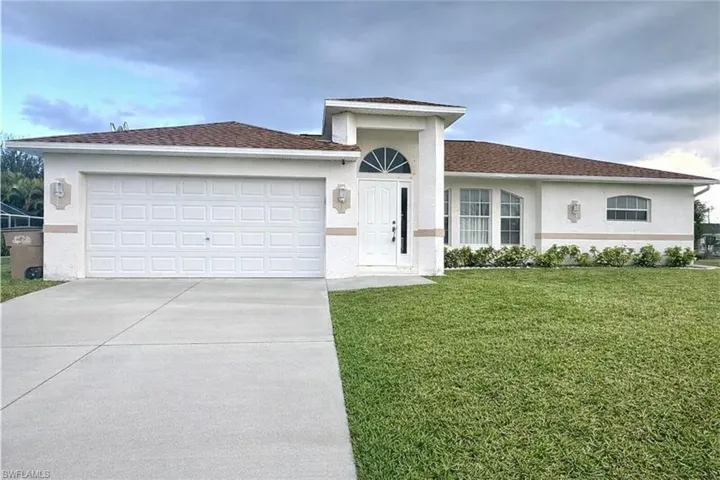 Ranch-style home with an attached garage, stucco siding, concrete driveway, a front lawn, and a shingled roof