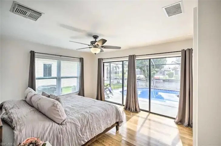 Bedroom featuring access to exterior, light wood-type flooring, and a ceiling fan