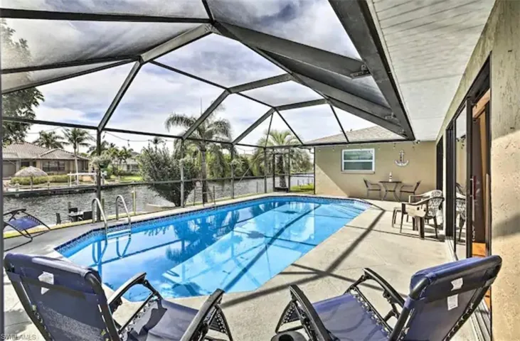 Outdoor pool featuring a sunroom, a patio area, and a lanai