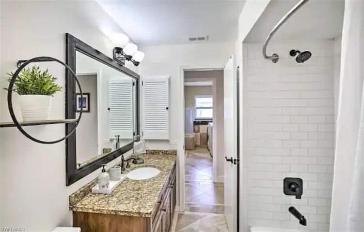 Full bathroom with shower / tub combo with curtain and vanity