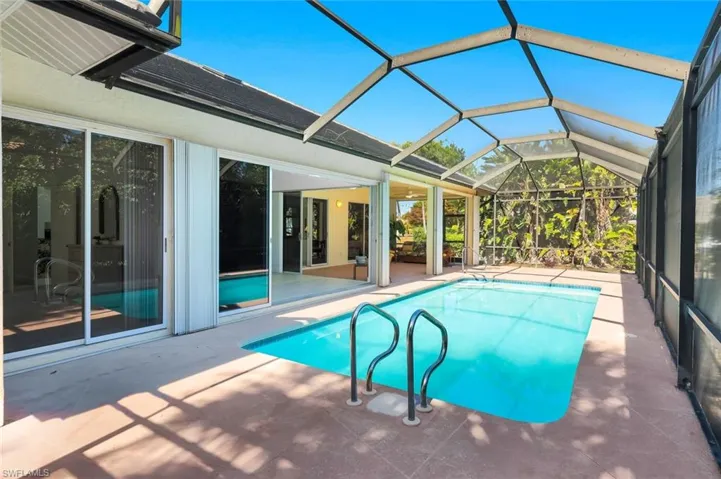 Outdoor pool featuring a lanai, a sunroom, and a patio