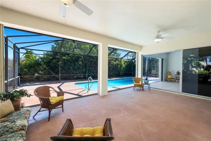 Outdoor pool with a patio, a sunroom, and a lanai