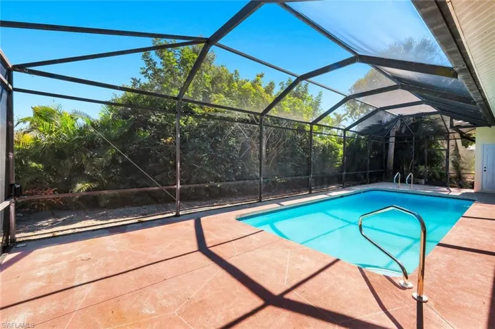 Swimming pool featuring a lanai, a sunroom, and a patio