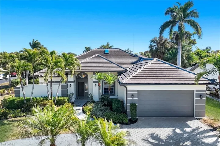 Ranch-style house featuring a tile roof, decorative driveway, a garage, and stucco siding