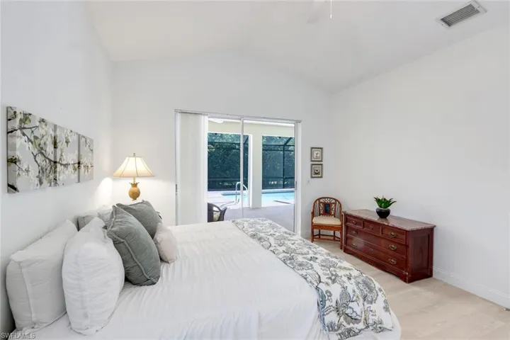 Bedroom with a sunroom, access to outside, lofted ceiling, light wood finished floors, and a ceiling fan