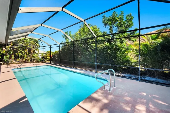 Swimming pool with glass enclosure, a sunroom, and a patio