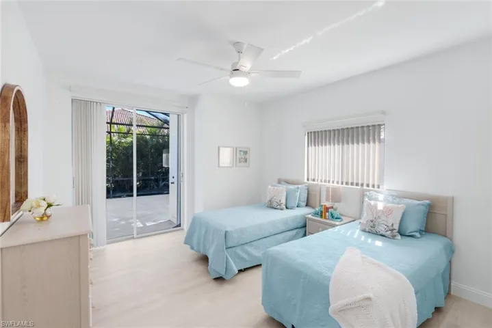 Bedroom with access to exterior, light wood finished floors, and multiple windows