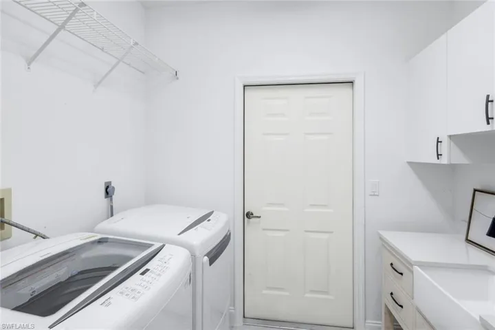 Laundry room with washer and clothes dryer and cabinet space