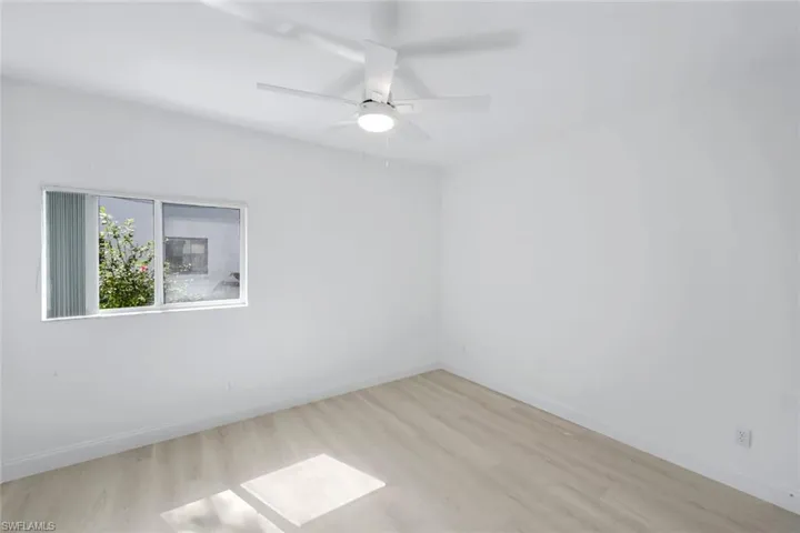 Empty room with light wood finished floors and ceiling fan