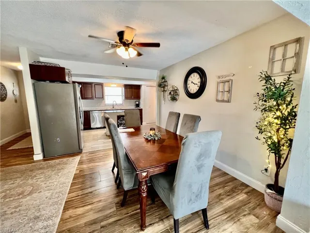 Dining room with ceiling fan, a textured ceiling, and light  wood-style floors. and a healthy amount of sunlight