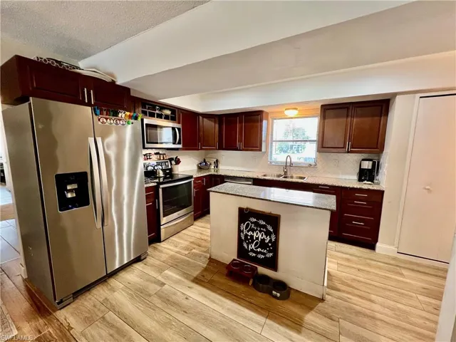 Kitchen with stainless steel appliances, sink, tile backsplash, a center island with GRANITE TOPS.