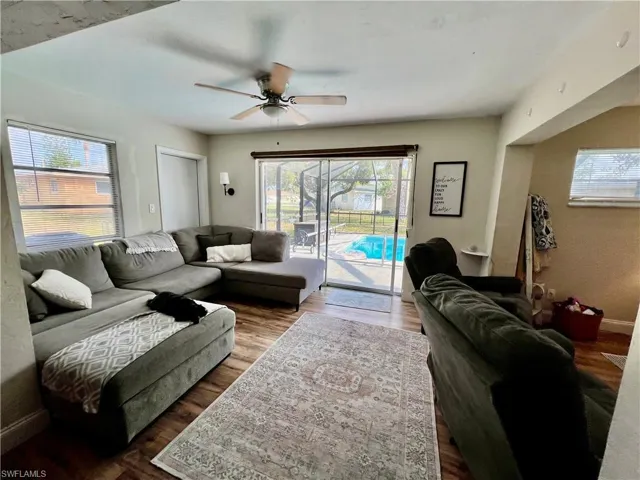 Living room featuring wood-style floors and ceiling fan with access to the pool area.