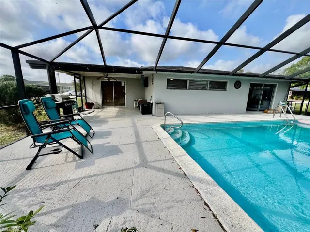 View of pool featuring a lanai, a patio, and ceiling fan