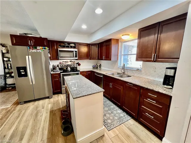 Kitchen with stainless steel appliances, sink, tile backsplash, a center island with GRANITE TOPS.