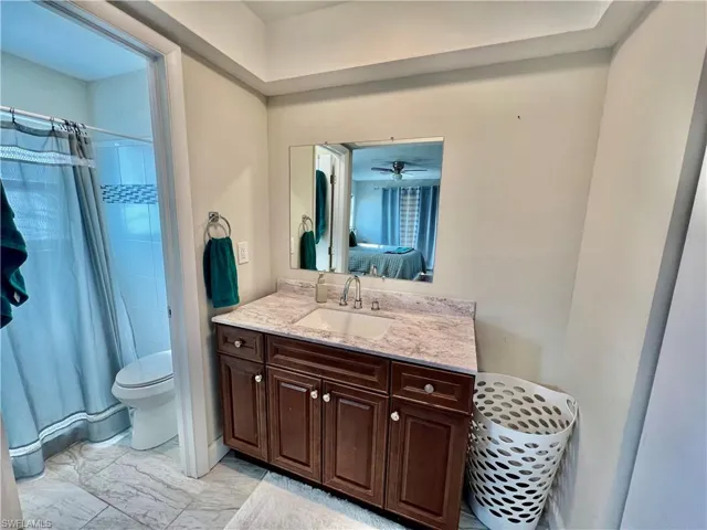 Primary bathroom with vanity, dressing area and a newly tiled walk in shower.
