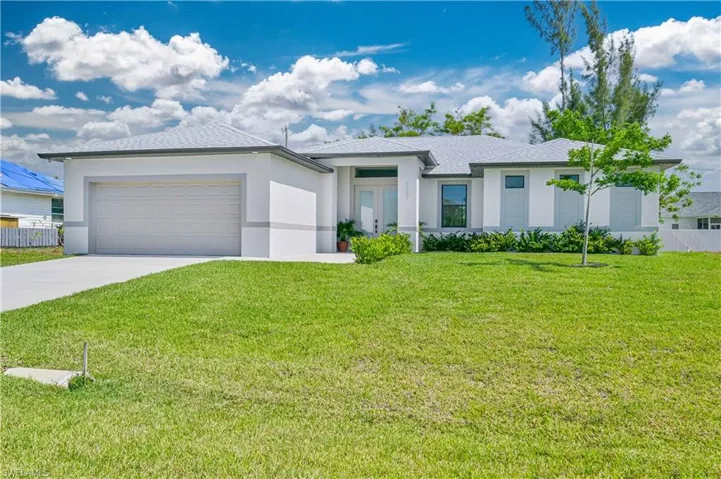 View of front of house featuring a front lawn and a garage