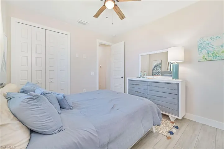 Bedroom with light wood-type flooring, a closet, and ceiling fan