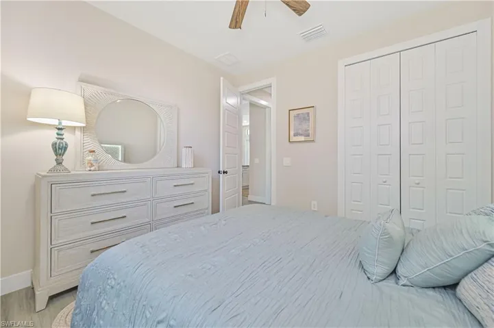 Bedroom featuring ceiling fan, a closet, and light wood-type flooring