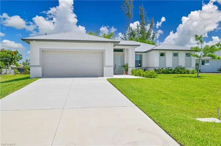 View of front facade with a garage and a front lawn