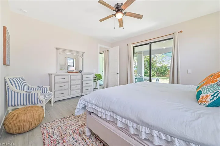 Bedroom with light hardwood / wood-style floors, ceiling fan, and access to exterior