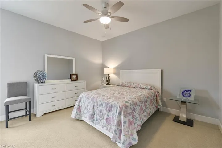 Bedroom with light colored carpet and a ceiling fan